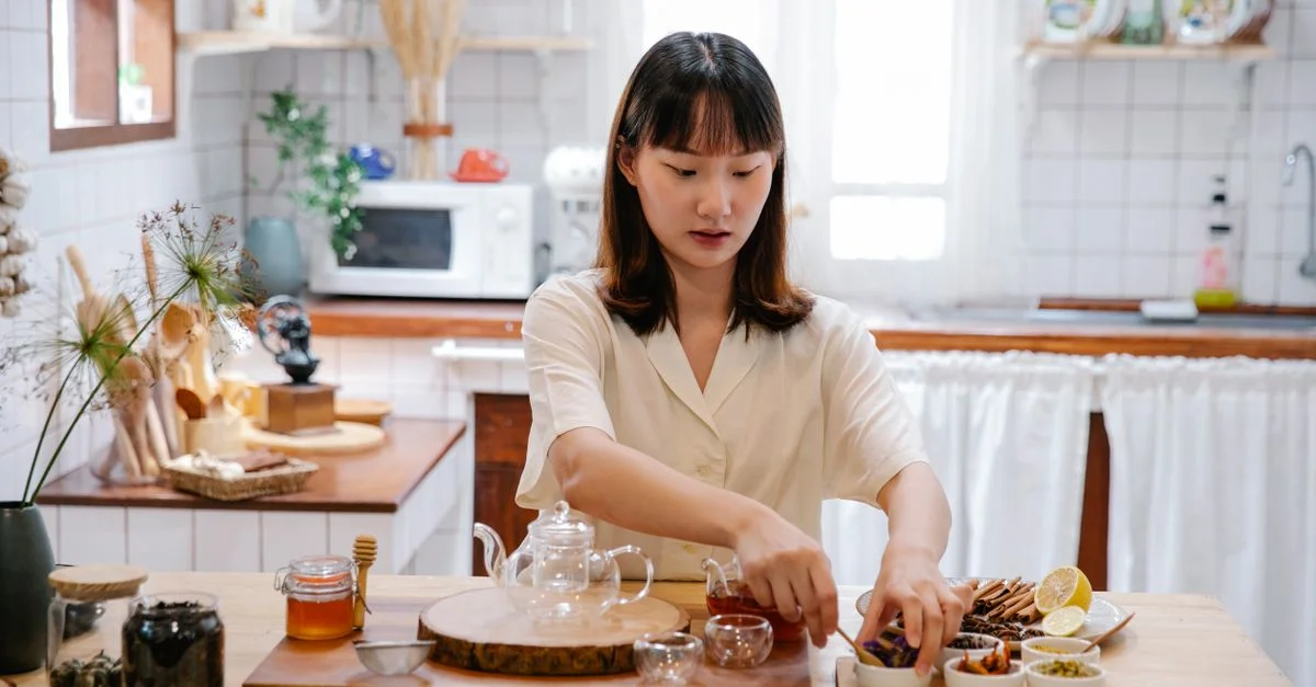 Femme préparant des ingrédients pour le thé dans une cuisine chaleureuse. Capture une atmosphère sereine et familiale.
