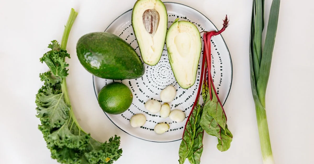 Un flat lay vibrant de légumes frais et d'avocat sur une assiette.